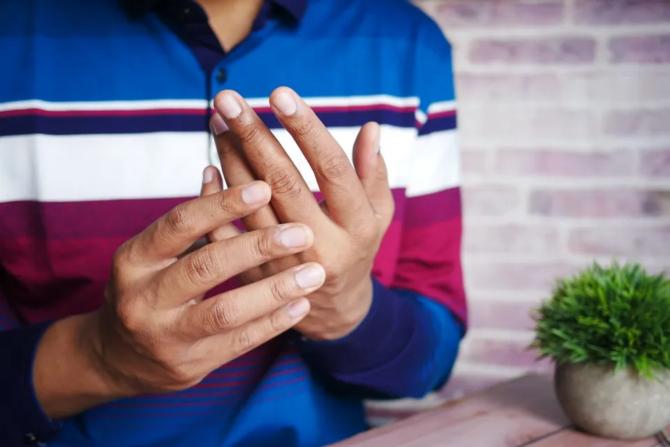 Personne se massant la main — douleurs liées à l'arthrose des doigts