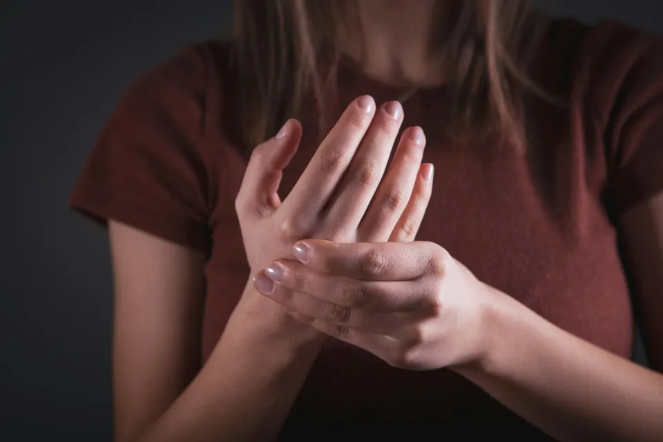 Femme se tenant le poignet douloureux, symptôme typique du syndrome du canal carpien