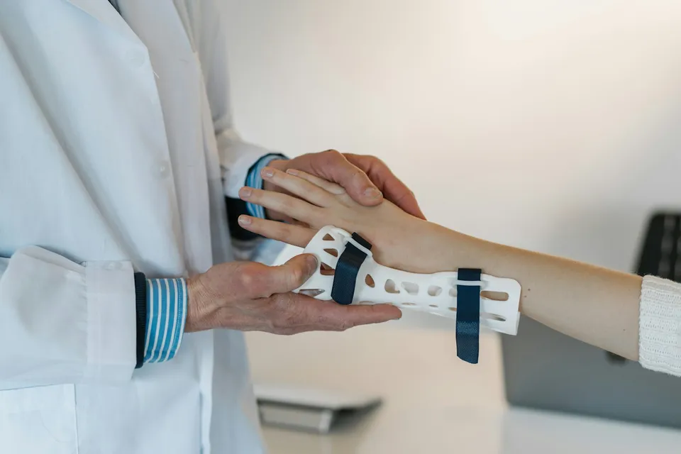 Médecin examinant la main d'une patiente, consultation médicale