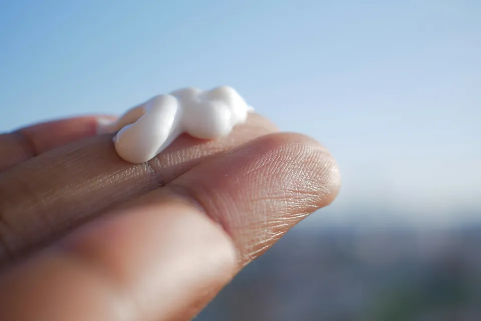 Crème hydratante sur les doigts, soin de la peau sèche
