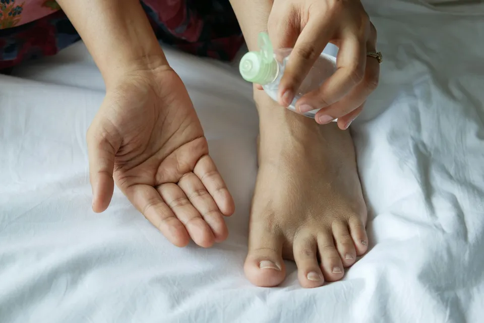 Soin hydratant appliqué sur un pied, routine de soin pour des pieds doux